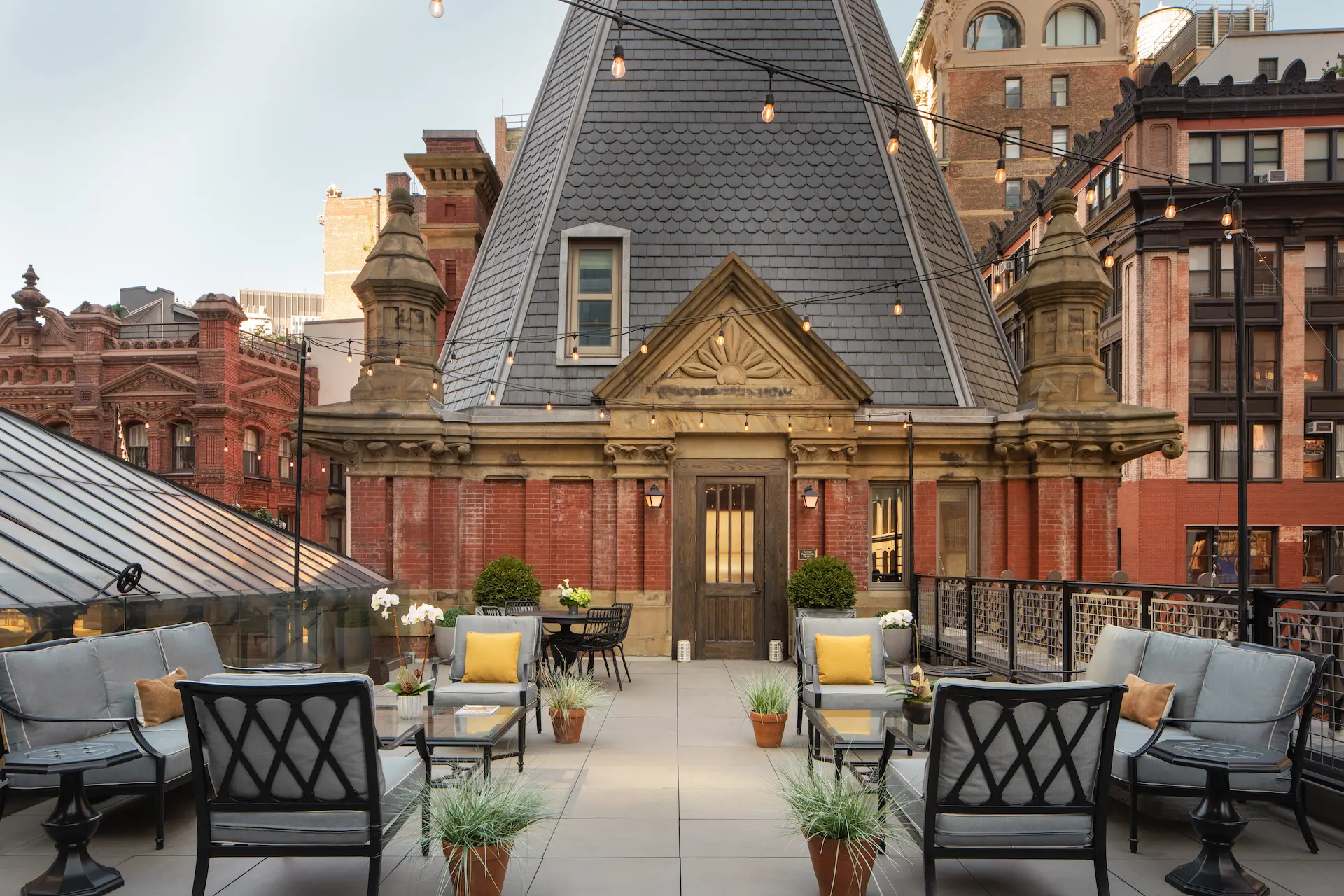 Rooftop relaxation area at The Beekman Hotel features sofas, providing a serene atmosphere.