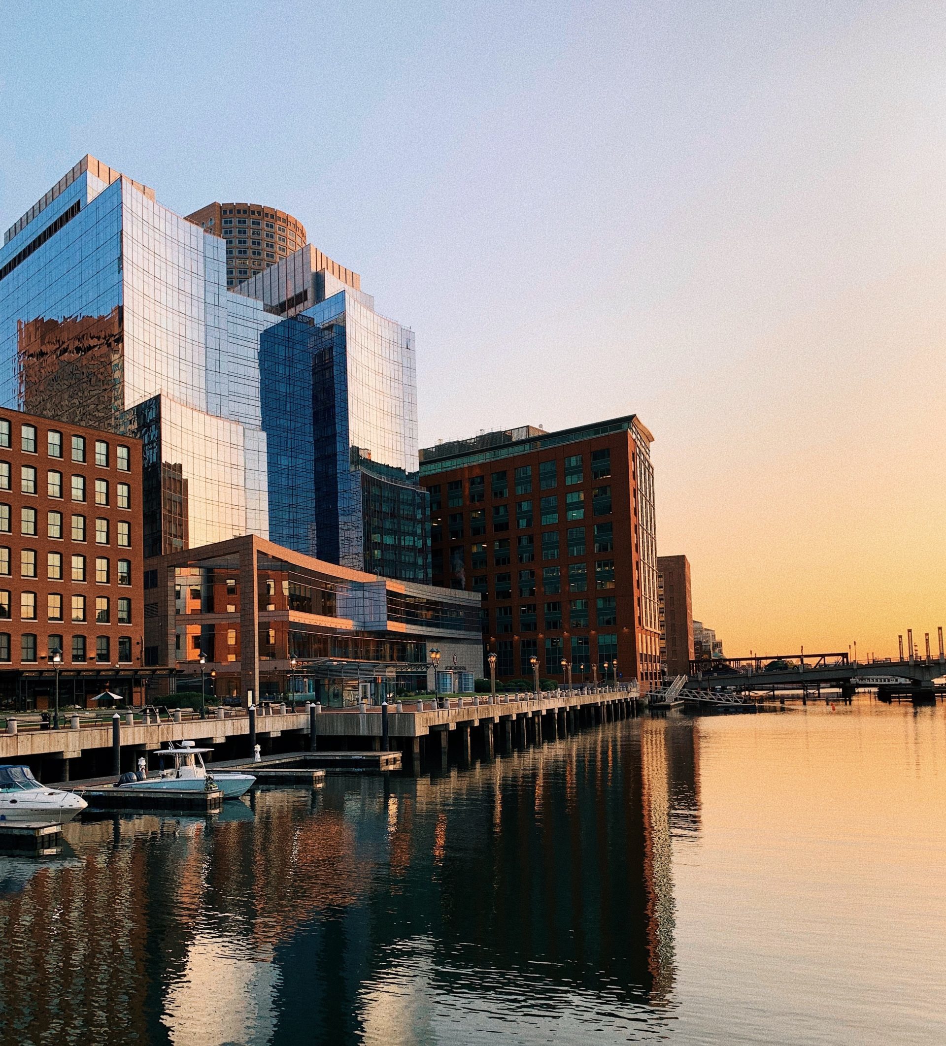 Captured image of the tall building standing adjacent to a river dock.