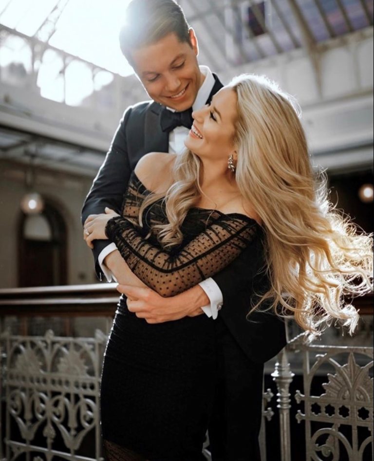 Happy couple holding hands, gazing at each other with beaming smiles and affectionate expressions.