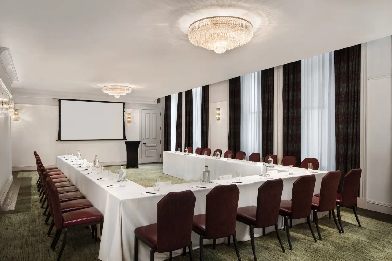 An elegantly decorated conference room, offering plentiful seating and subdued lighting.