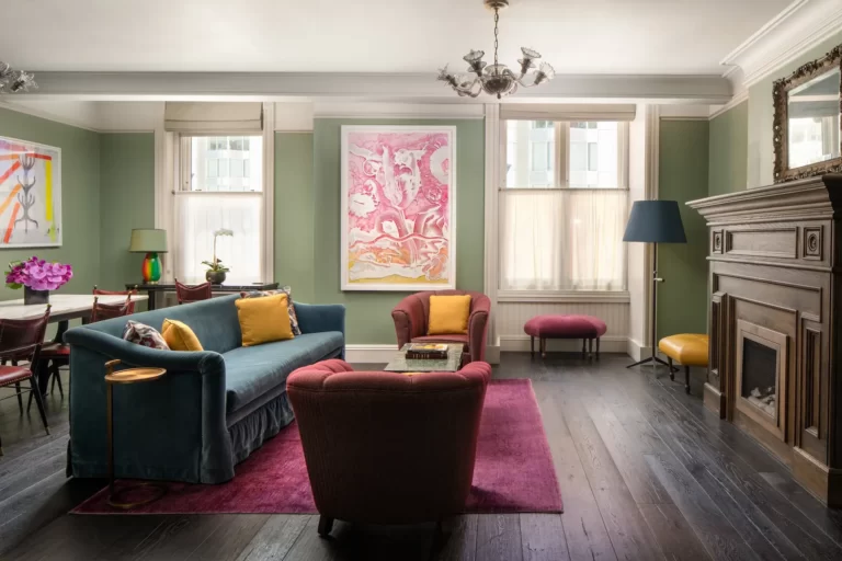 Cozy lounge at The Beekman Hotel with elegant sofas, armchairs, and a classic fireplace.