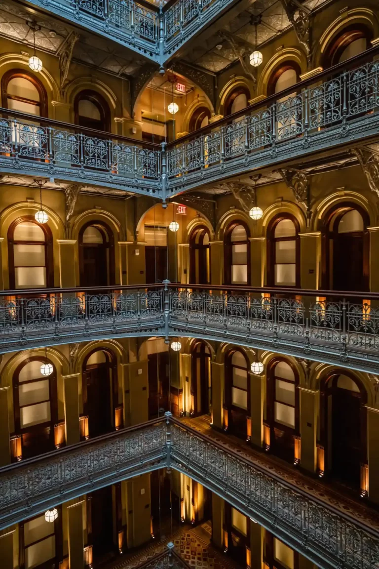 Interior of The Beekman Hotel in NYC, featuring ornate balconies, warm lighting, and vintage architectural charm.