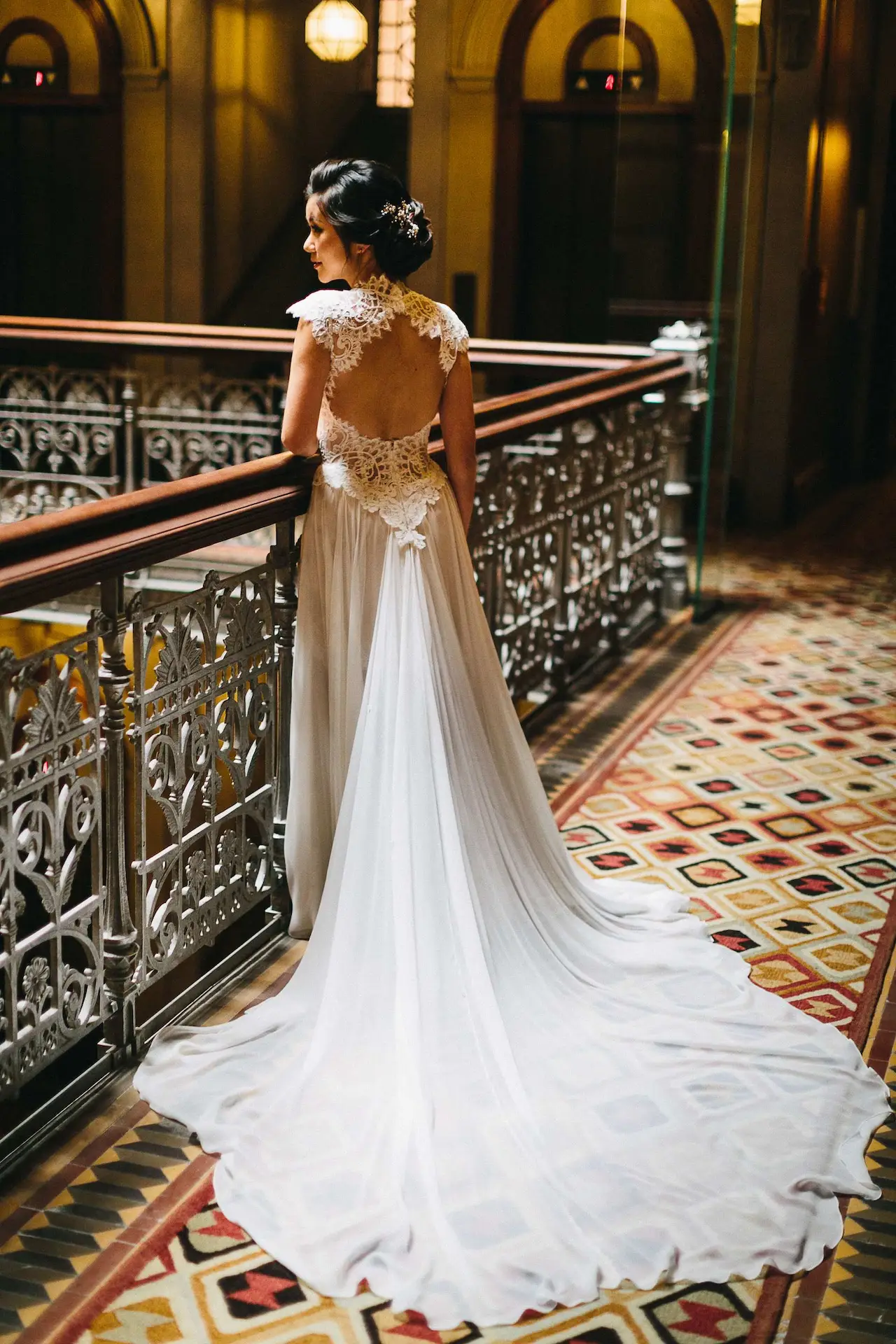 A beautiful girl in a wedding dress is standing in the corridor.